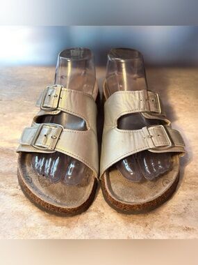 Muk Luks silver Marla sandals feature two adjustable buckle straps